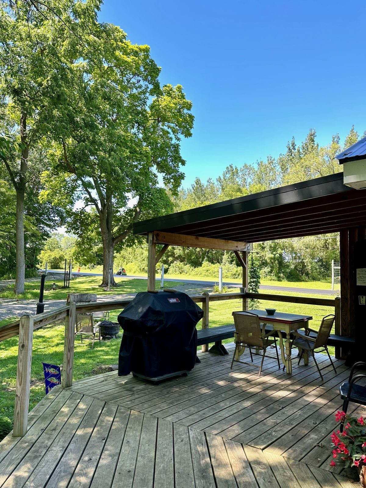 Covered deck area with grill and outdoor dining table