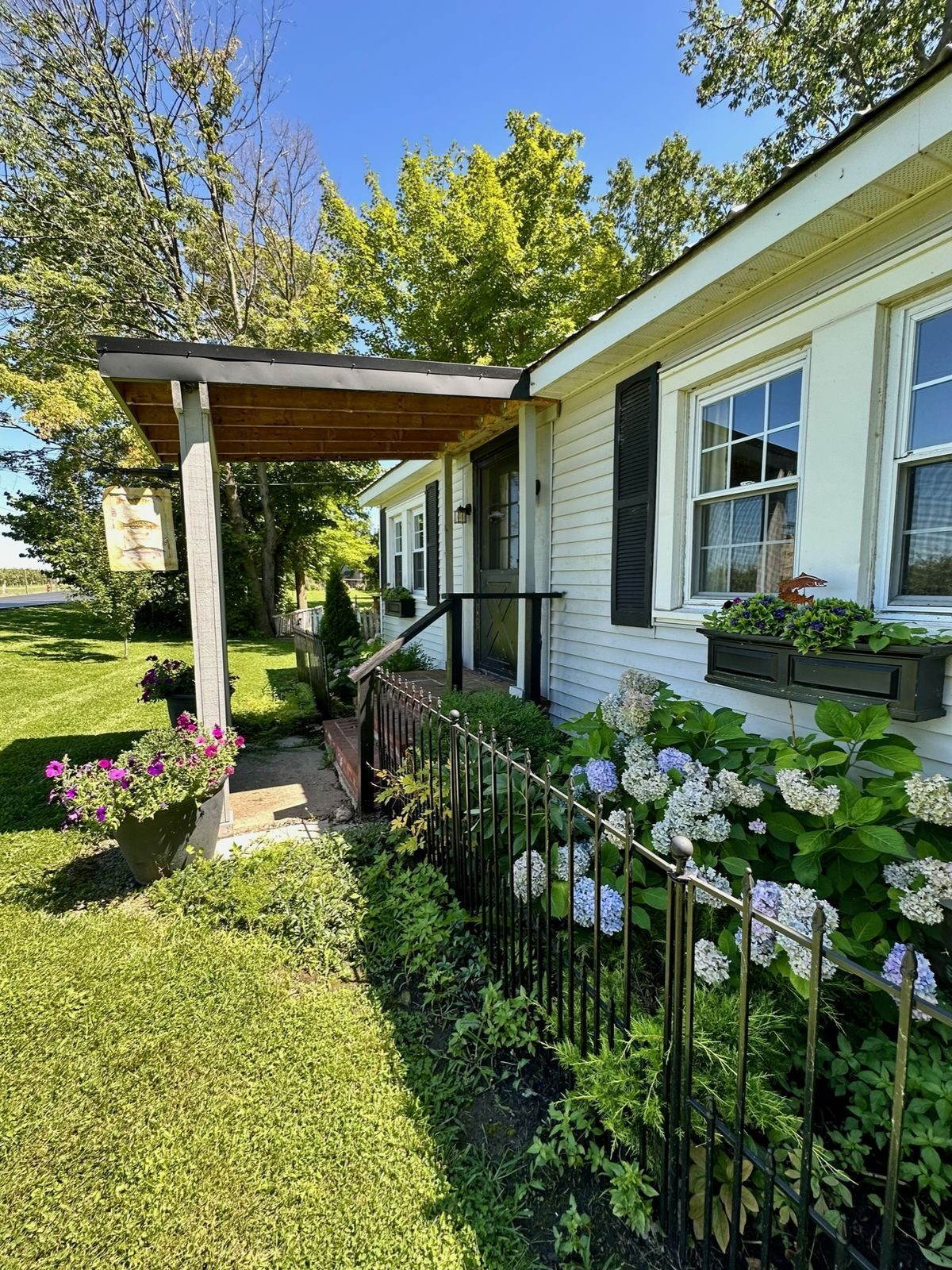 Cottage front porch with blooming hydrangeas and covered entryway